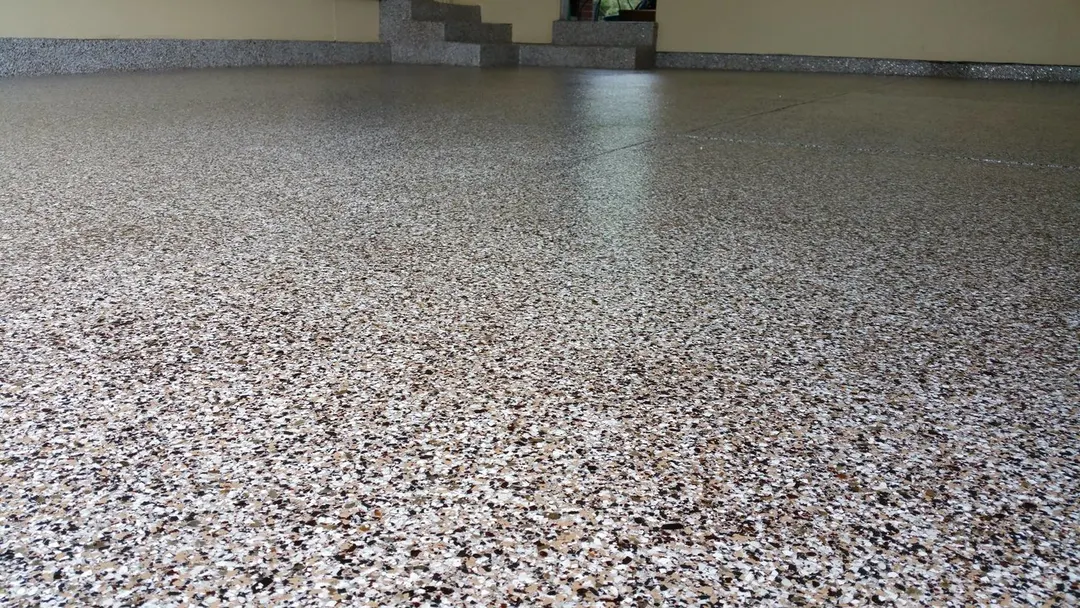 Close-up of a gray, white and brown vinyl flake epoxy floor surface