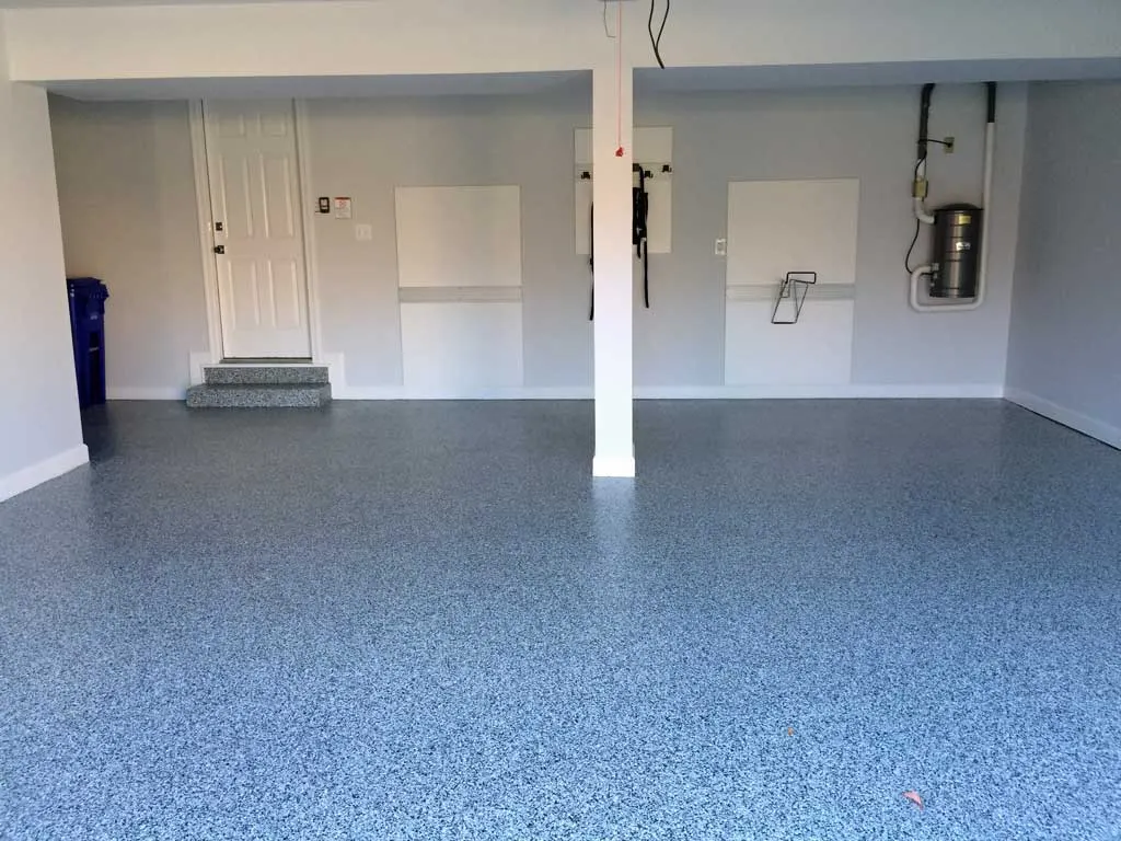 Two-car garage with a blue-gray flake epoxy floor, white walls and a center support post