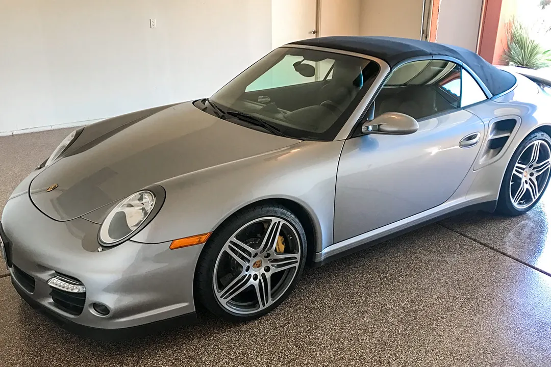 Silver convertible sports car parked on a glossy flake epoxy garage floor